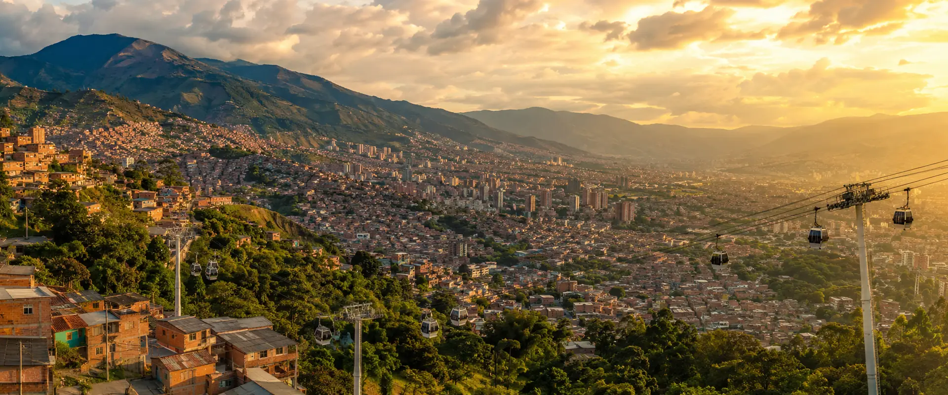 Aerial view of Medellín and the Aburrá Valley at golden hour with Metrocable gondolas